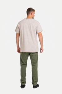 Hellgraues T-Shirt mit kurzen Ärmeln und lockerer Passform, kombiniert mit olivgrünen Hosen und schwarzen Schuhen, von hinten betrachtet.