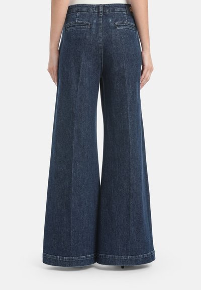 Wijde donkere spijkerbroek van denim met een gladde textuur, voorzien van twee achterzakken en een nette zoom. De tailleband heeft een logotag.