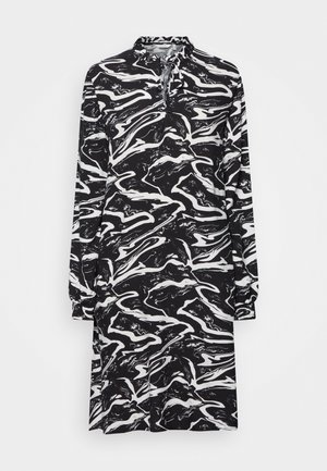 Czarna i biała sukienka z długim rękawem z marmurkowym wzorem, z wysokim kołnierzem i dekoltem bez guzików, wykonana z miękkiego materiału.