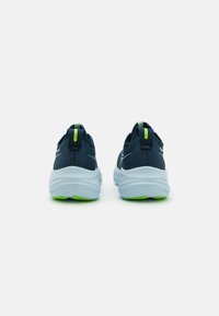 Scarpe sportive blu navy con tomaia in rete, un sottopiede bianco e una suola verde. Include un passante sul tallone per indossarle facilmente.