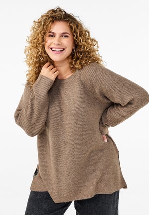 Beige knitted sweater with a loose fit, round neckline, and long sleeves. Side splits and textured fabric create a casual design.