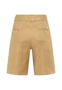 Short beige longueur genou avec une ceinture, une passants de ceinture, deux poches arrière à boutons et une petite étiquette métallique de marque sur le côté droit.