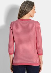Gestreifter pinkfarbener Pullover mit drei Viertel-Ärmeln, einem runden Halsausschnitt sowie gerippten Bündchen und Saum. Der Stoff sieht weich und strukturiert aus.