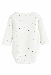 Bodysuit blanc à manches longues avec un motif de petites étoiles noires. Tissu doux avec un col rond et des boutons-pression au bas.