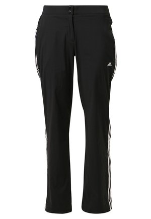 Czarne spodnie dresowe Adidas z białymi bocznymi paskami, z przodem zapinanym na guziki oraz logo Adidas na górnej części uda.