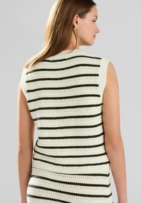 Maglione senza maniche di colore crema con righe orizzontali verde scuro, caratterizzato da una trama testurizzata e un design aderente in vita.