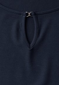 Navy blue fabric with a smooth texture features a V-shaped neckline and a silver clasp detail at the center. Stretchy and form-fitting.