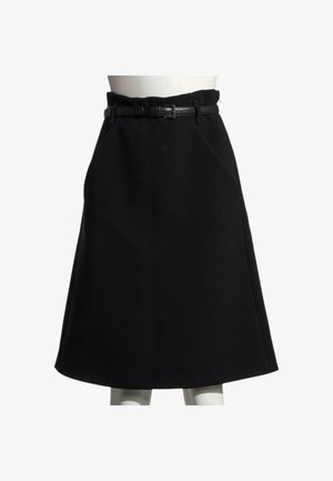 Jupe noire longueur genou en A avec une fine ceinture en cuir noir à la taille d'un mannequin blanc sur fond blanc.