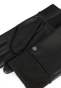 I guanti in pelle nera presentano un polsino a costine nero e una patta in pelle sovrapposta. Un piccolo bottone metallico con il marchio "Touch" è visibile.