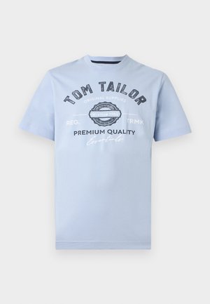 Svijetloplavi pamučni majica s okruglim izrezom, kratkim rukavima i otisnutim tekstom u tamnoplavoj boji. Sadrži dizajn s logotipom i godinom osnivanja.