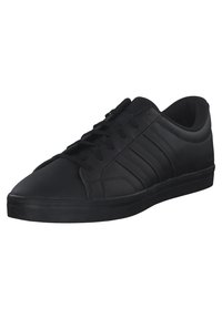 Zapatilla negra hecha de material sintético liso, con un diseño de bajo perfil, suela plana y tres franjas laterales. Cierre clásico con cordones.