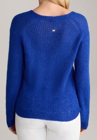 Królewsko niebieski sweter z dzianiny o prążkowanej fakturze, z długimi rękawami i okrągłym dekoltem. Posiada mały, subtelny element z logo na plecach.