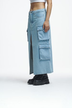 Jupe en denim bleu clair avec poches cargo et une fente latérale haute jusqu'à la cuisse, associée à des bottes noires à lacets épaisses.