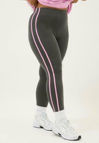 Grå leggings med rosa sidremsor, hög midja, slät textur, kombinerade med vita sneakers och vita strumpor.