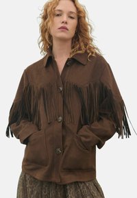 Brown suede jacket featuring front pockets, button closures, and fringe detailing along the sleeves and shoulders.