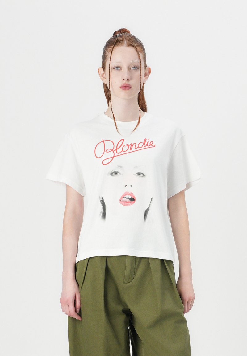 White cotton t-shirt featuring a graphic face print and red "Blondie" text. Relaxed fit with short sleeves and a crew neckline.