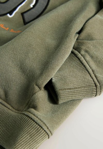 Oliven grøn sweatshirtstof med ribbede manchetter og kant. Blød tekstur med let stræk, der fremhæver et afslappet design.