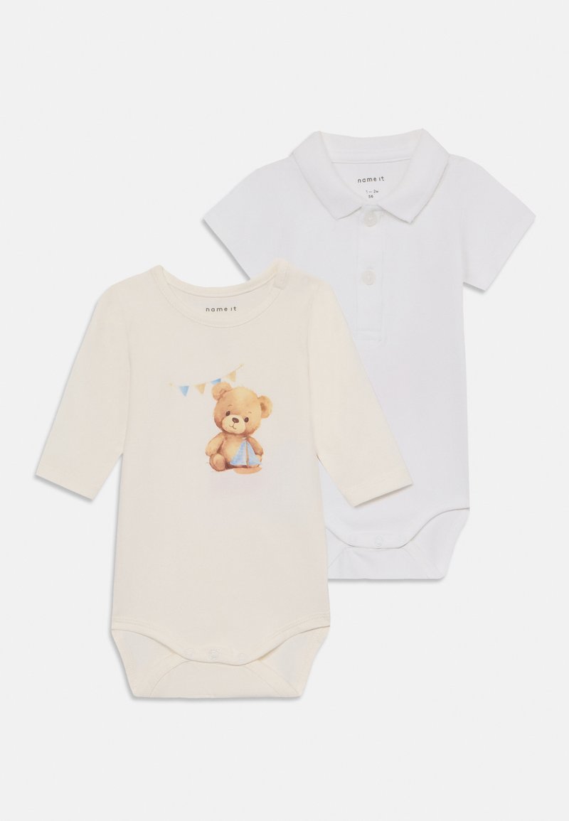 Two baby bodysuits: one beige with a teddy bear graphic and bunting, and one white polo style with a collar and button detail.