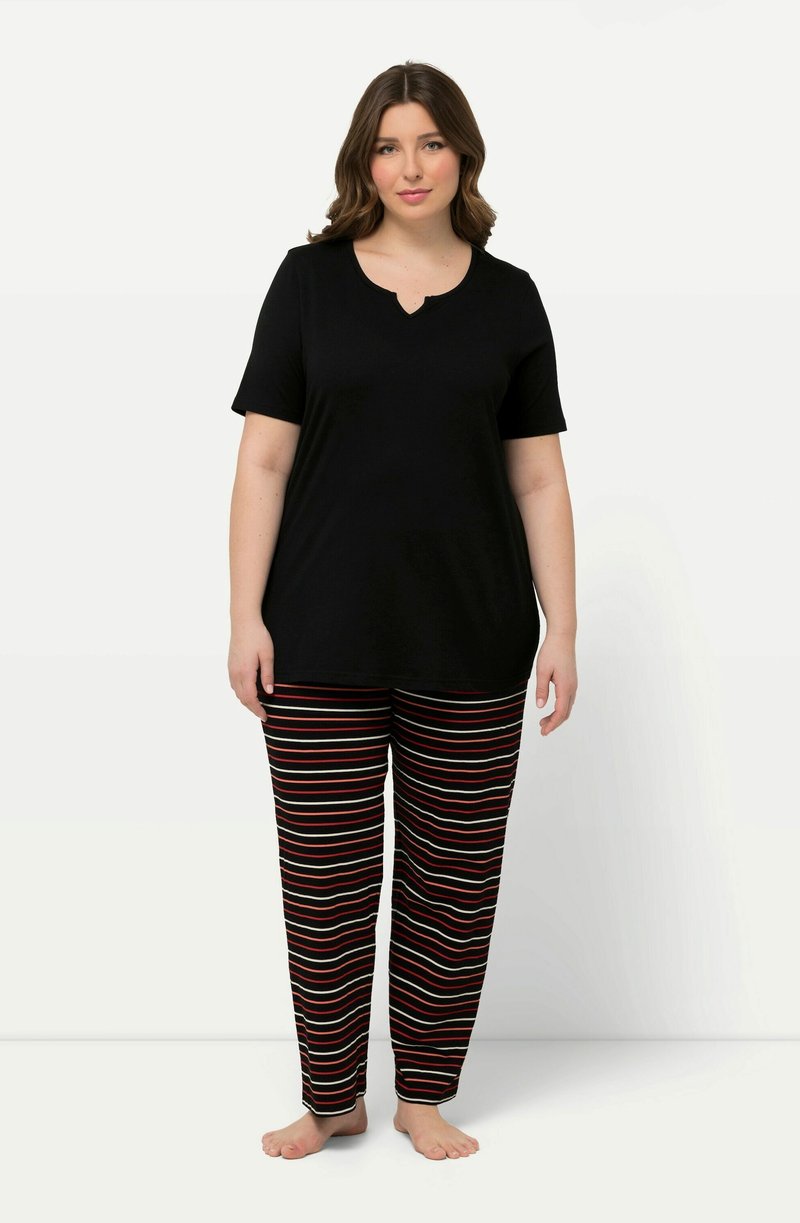 Top negro de manga corta con escote en forma de pico combinado con pantalones de pijama a rayas rojas y blancas. Ambos presentan una tela suave y un ajuste relajado.