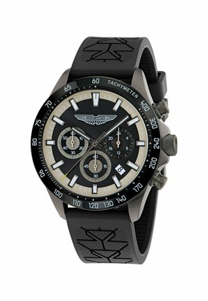 Reloj cronógrafo con correa de goma negra y detalles texturizados. Cuenta con esfera negra, marcadores de horas plateados, tres subesferas y visualización de fecha.