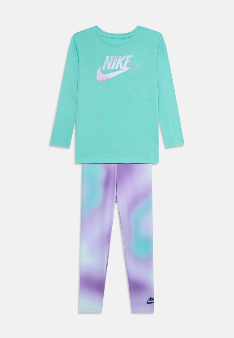 Turkusowa koszulka Nike z długim rękawem z purpurowym logo Nike, zestawiona z legginsami tie-dye w kolorze purpurowym i turkusowym, z małym czarnym logo Nike.