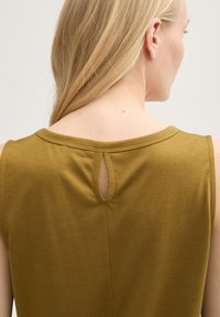 Olivgrön ärmlös topp med rundad halsringning, nyckelhålsdetalj på baksidan och mjuk, slät tygtextur.