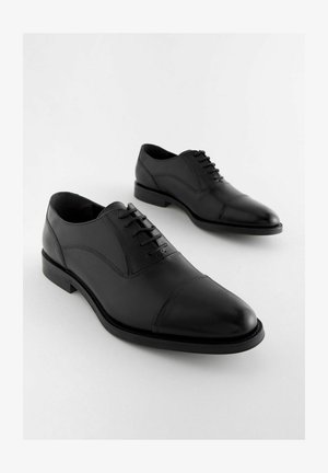 Juodas odinis suknelės batų modelis, su lygiu paviršiumi, apvaliu nosiu ir penkiais akelėmis. Kairėje ir dešinėje pusėje turi subtilų išlenkimą ir žemą kulną.