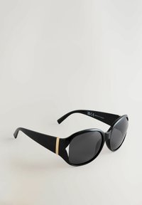 Occhiali da sole neri con finitura lucida, lenti curve, una leggera forma a occhi di gatto e un accento dorato sulle aste. Aste esterne con texture.