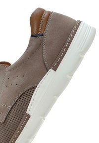 Braune Leder-slipper mit einem perforierten Design, weißer Gummisohle und kontrastierendem, hellbraunem Akzent an der Ferse.