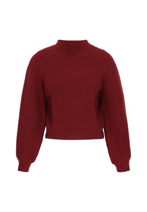 Pull en maille rouge côtelée avec un col montant, une coupe courte, des manches raglan et un tissu texturé. Des lignes épurées et simples mettent en valeur la silhouette.