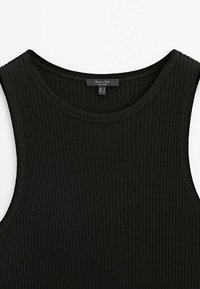 Haut sans manches noir en maille côtelée avec encolure ronde et étiquette de marque cousue à l'intérieur du col.