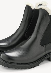 Schwarze Lederstiefeletten mit elastischen Seiteneinsätzen, strukturiertem Wollfutter und robusten Gummisohlen. Glatte Oberfläche mit einem abgerundeten Zehenbereich.