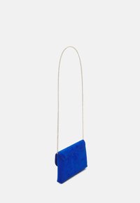 Bolso cruzado de tela azul con una textura suave, cierre de solapa y una correa de cadena dorada, que presenta una forma rectangular simple.