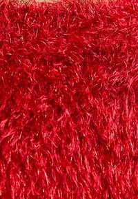 Czerwony, puszysty tekstylia o wyraźnie fakturowanej powierzchni, z błyszczącym, syntetycznym wykończeniem, które odbija światło, tworząc żywy wygląd.