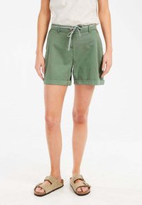 Khaki groene shorts met een opgerolde zoom, stoffen strikriem met een gestreept patroon, gecombineerd met beige sandalen. Casual katoenmateriaal.