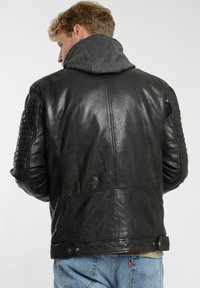 Sort læder bikerjakke med quilted skulder- og albueaccenter, der har en grå snørerhætte og en afslappet pasform.