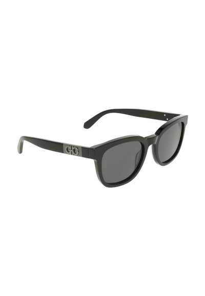 Black sunglasses with a rounded frame, gray tinted lenses, and a logo detail on the temple. Made of lightweight plastic material.
