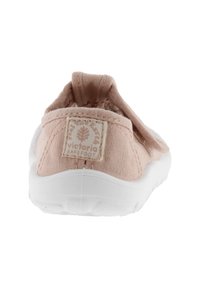 Zapato slip-on de lona en rosa claro con suela de goma blanca. Cuenta con una etiqueta en la parte posterior y un upper texturizado para mayor transpirabilidad.