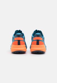 Blauwe en oranje sport sneakers hebben een gestructureerde bovenkant, een gevoerde zool en een trekband aan de achterkant voor eenvoudig aan- en uittrekken. Rubberen zool voor grip.