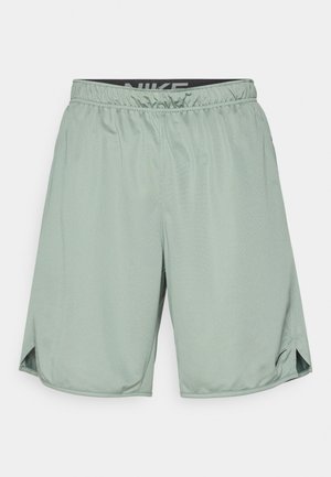 Grønne treningsshorts med elastisk midje og en svart Nike-logo. Laget av lett materiale, har de sidespalter for bedre bevegelighet.