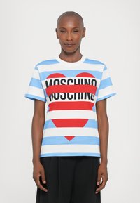 Korteermet t-skjorte i bomull med blå og hvite vertikale striper, stort rødt hjertegrafikk og fet svart "MOSCHINO" tekst over brystet.