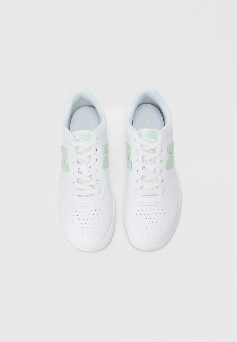 Zapatillas de cuero blancas con acentos verdes, punta redonda, diseño de cordones, detalles perforados en los laterales y un collar suave y acolchado.