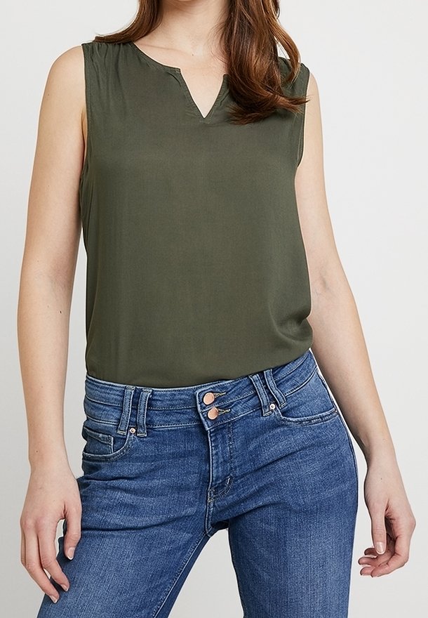 Olive green sleeveless blouse with a v-neck, made of smooth fabric. Paired with blue high-waisted jeans, featuring two front buttons.