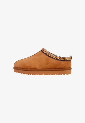 Tan slip-on tøfler med blød ruskindsstruktur, zigzag broderet kant i hvid og gul, og en gummisål med riller.