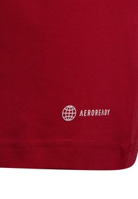Maglietta atletica rossa realizzata in tessuto morbido, con il logo "AEROREADY" visibile e una texture liscia con orlo pulito.