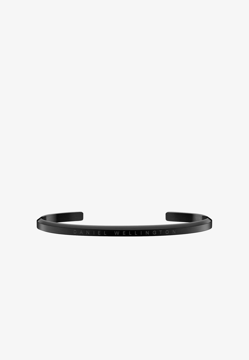 Fekete fém karszalag letisztult, minimalista dizájnnal. Az külső felületén gravírozott "DANIEL WELLINGTON" felirat található. Sima textúra, nyitott végek.