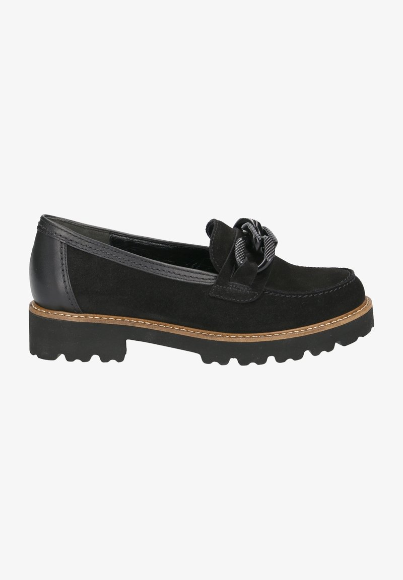 Mocassin en daim noir avec semelle épaisse, coutures couleur noisette et boucle décorative noire sur le dessus, vu du côté extérieur.