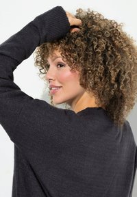 Dunkelgrauer Pullover mit gerippten Bündchen und Halsauschnitt, weicher Textur, lockerer Passform, mit abgerundetem Saum und dezenten Nähten.