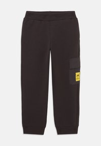 Black sweatpants with a ribbed waistband and cuffs. Includes a side cargo pocket featuring a yellow label. Made from cotton-blend fabric.