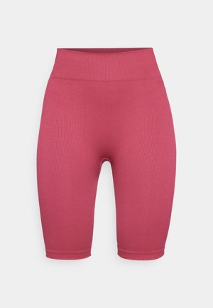 Pantalones cortos de ciclismo de canalé, de longitud media hasta el muslo, en un color rosa sólido y con una cintura alta. Textura suave sin hardware visible ni adornos.